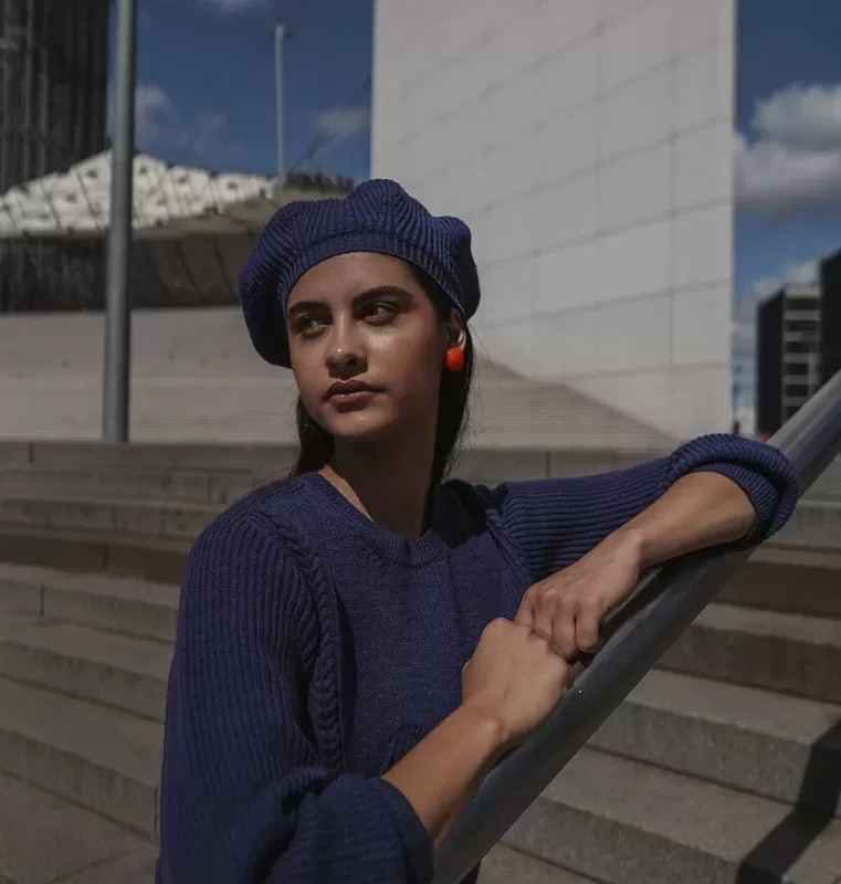 jeune femme avec pull et béret bleu marine assortis à la Défense Paris