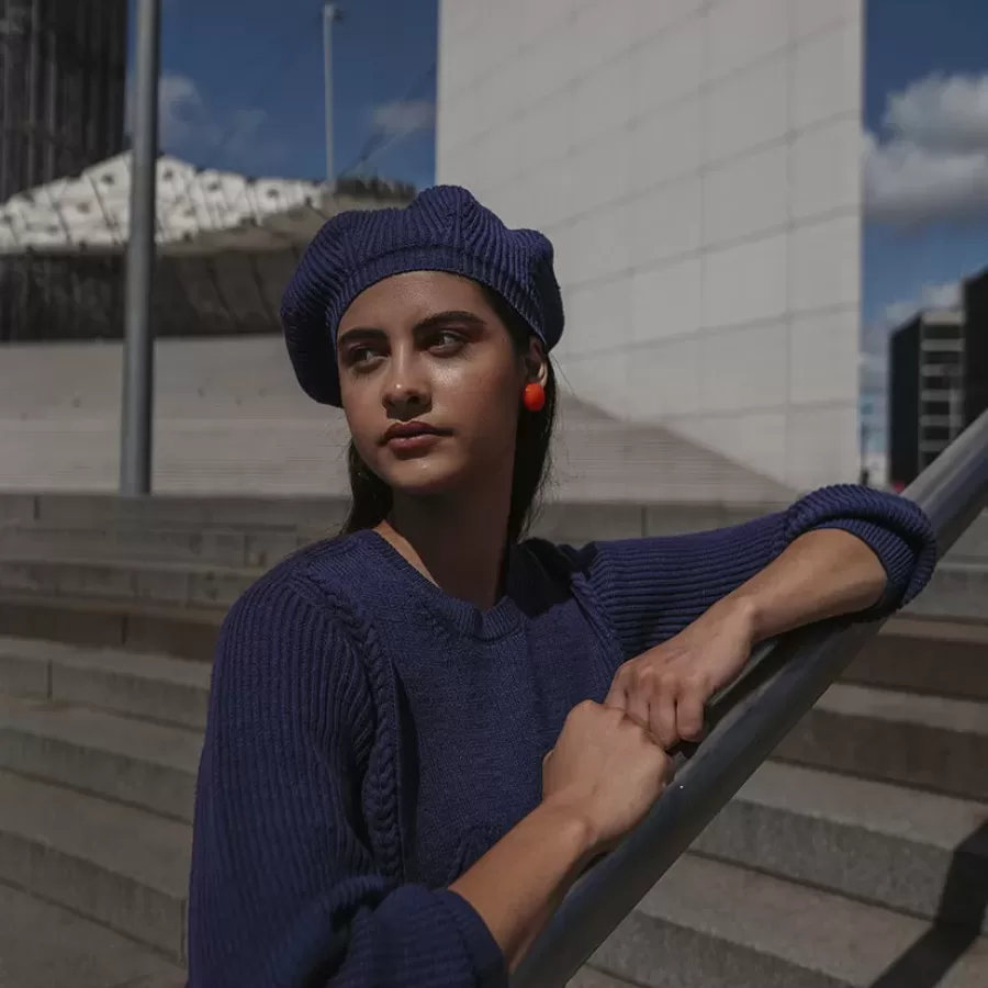 jeune femme avec pull et béret bleu marine assortis à la Défense Paris